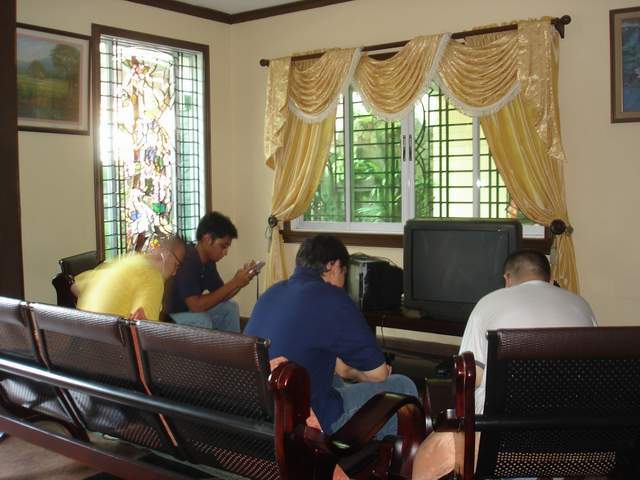 Sitting down, each one doing his own thing.
